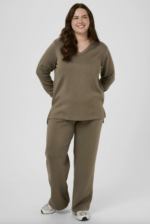 Woman wearing a brown outfit on a gray background
