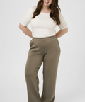 Woman wearing a white top and brown pants on a white background