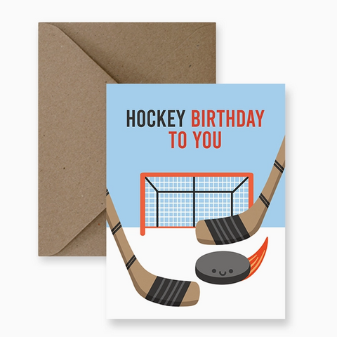 Hockey-themed birthday card with sticks, puck, and goal on a blue background, accompanied by a brown envelope.