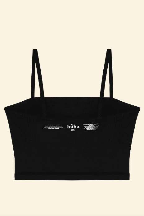 Black crop top with thin straps on a beige background