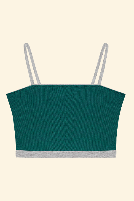 Green crop top with thin straps on a beige background