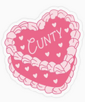 Heart-shaped pink cake with 'CUNTY' text on a white background