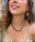 Woman wearing layered necklaces and earrings outdoors