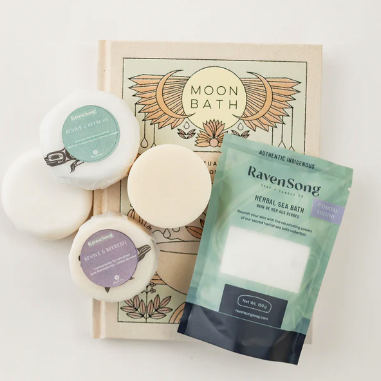 Three round bath bombs with labels and a package of 'Raven Song' on a white background.