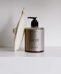 Picot body wash bottle with a pump and washcloth on a white surface