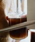 Coffee being brewed into a glass carafe with a blurred background