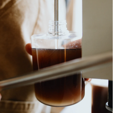 Coffee being brewed into a glass carafe with a blurred background