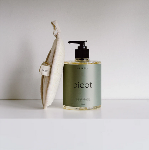 Picot hand soap bottle with a towel on a white background