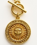 Gold pendant with sun design and chain on a white background