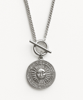 Silver necklace with a sun pendant on a white background