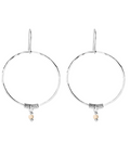 Pair of silver hoop earrings with small pink beads on a white background