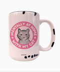 Pink mug with a cat illustration and text on a white background