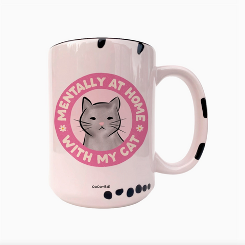 Pink mug with a cat illustration and text on a white background