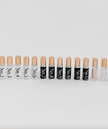 Row of lip balm tubes with visible brand names on a white background