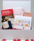 Box with sexual products and cards on a heart-patterned background