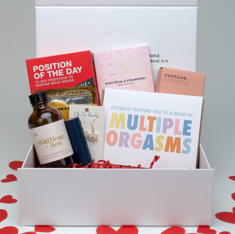 Box with sexual products and cards on a heart-patterned background