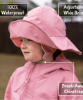 Child wearing a pink waterproof rain hat with features highlighted.