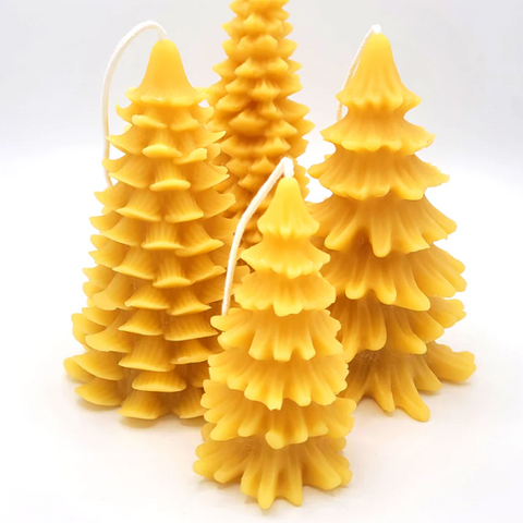A set of three yellow beeswax candles shaped like Christmas trees, displayed against a white background.