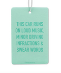 A green car air freshener with text stating 'This car runs on loud music, minor driving infractions & swear words'.
