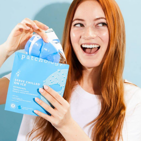Woman holding a package of patchology hydrogels against a light blue background
