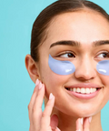 Woman wearing eye patches with a blue background