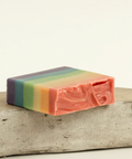 Colorful striped soap on a wooden surface with 'Raven Song' branding above.