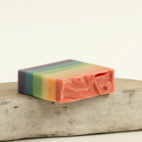 Colorful striped soap on a wooden surface with 'Raven Song' branding above.