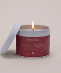 Candle in a red container labeled 'Raven Song Basket of Berries' on a beige background