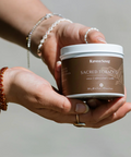 Person holding a container labeled 'RavenSong Sacred Tobacco' against a neutral background