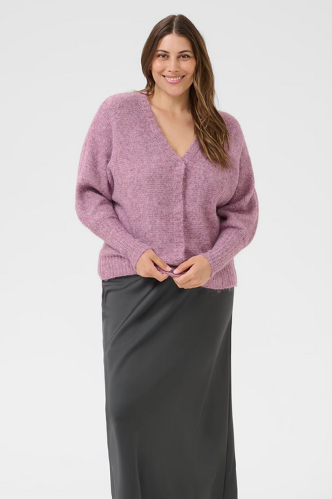 Woman wearing a pink sweater and gray skirt on a product page
