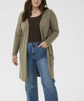 Woman wearing a green cardigan and blue jeans on a white background