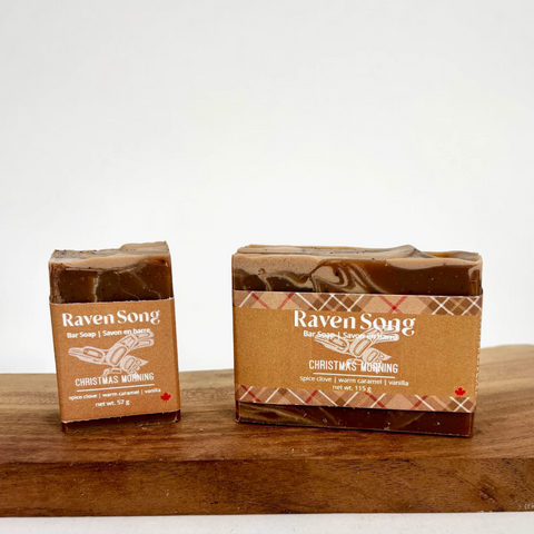 Two bars of Raven Song soap on a wooden surface with a white background