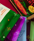 Tea packages with colorful labels on a red surface, displayed on a website page.