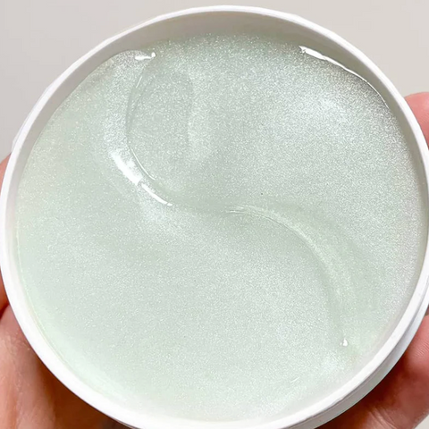 White round container with textured surface held in a hand, with a blurred product page in the background.