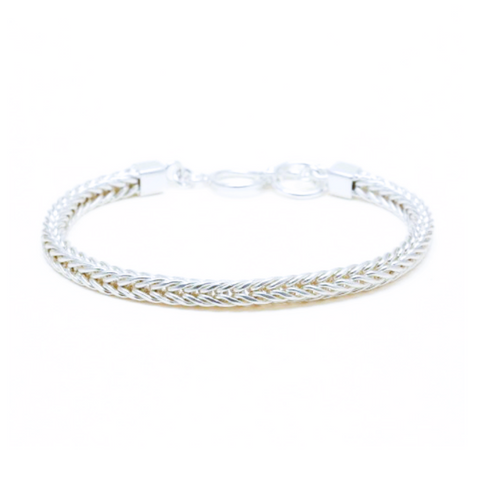 Silver bracelet with a subtle pattern on a white background