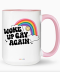 White mug with pink handle featuring a rainbow and text on a white background