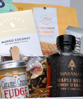 Assorted food items including a bottle of Wabanari maple syrup, fudge, and other packaged goods.