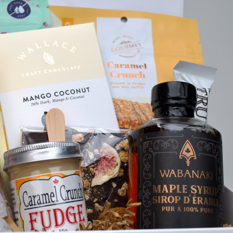 Assorted food items including a bottle of Wabanari maple syrup, fudge, and other packaged goods.
