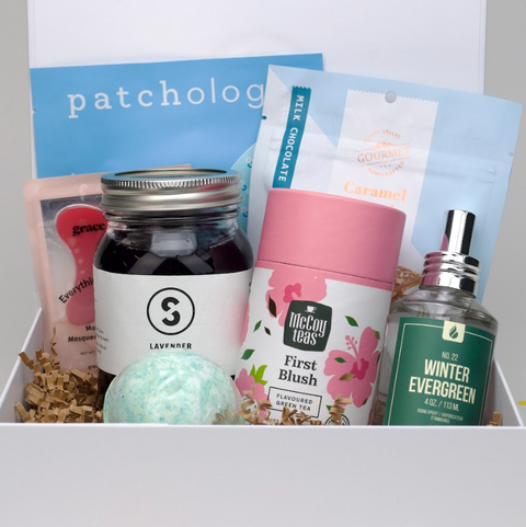 Assorted products including a bottle, tea canister, and bath bomb in front of a 'patchology' box.