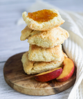 Stack of peach cobbler cookies on a wooden board with peaches