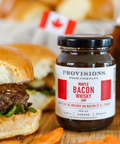 Bottle of Provisions Bacon Whisky with a burger on a wooden surface