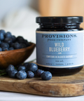 Provisions Wild Blueberry product on a wooden surface with blueberries around