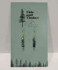 Pair of earrings on a 'Tide and Timber' branded card with nature-themed design.