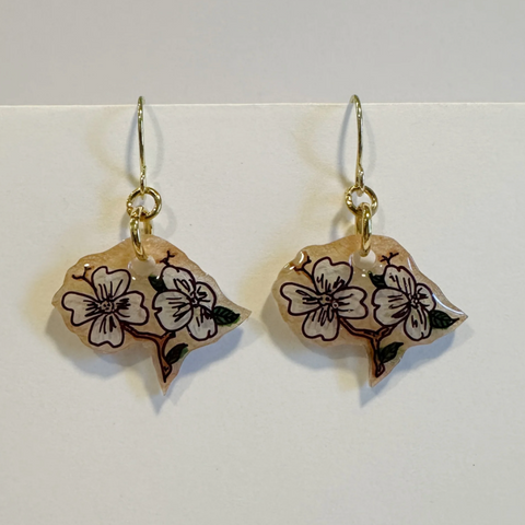 Pair of earrings with floral designs on a white background