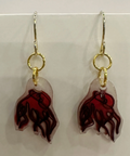 Pair of earrings with red and clear design on a light gray background