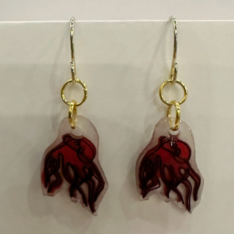 Pair of earrings with red and clear design on a light gray background