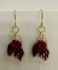 Pair of earrings with red and gold design on a light gray background