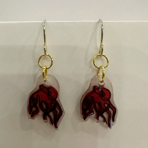 Pair of earrings with red and gold design on a light gray background