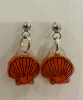 Pair of earrings with orange shell designs on a light background