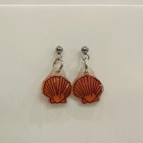 Pair of shell-shaped earrings on a light gray background